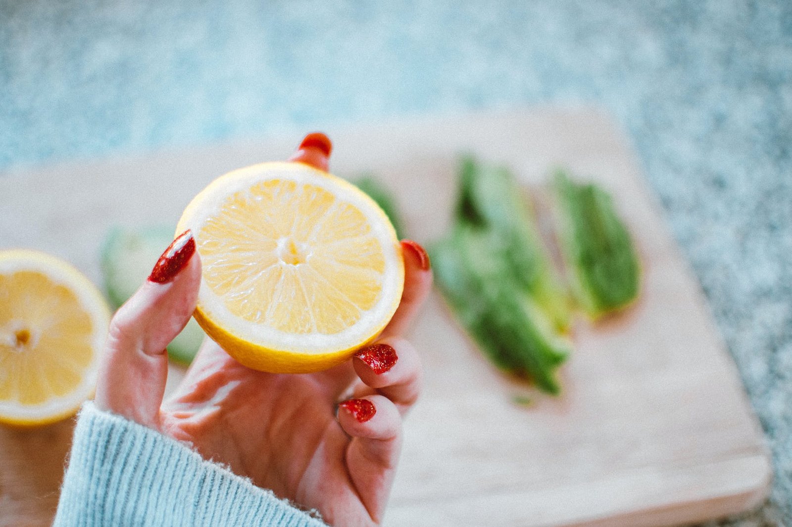 selective focus photography of person holding sliced lemon